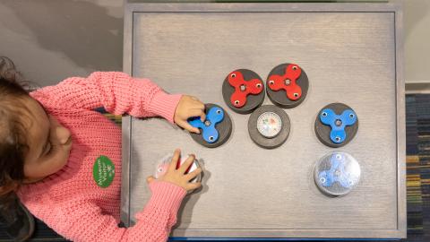 a child plays with a tabletop magnet spinner exhibit